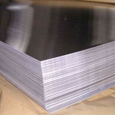 several stacks of aluminum sheets sitting on top of a table