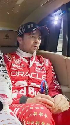 two men sitting in the back of a car wearing red and white outfits with stars on them