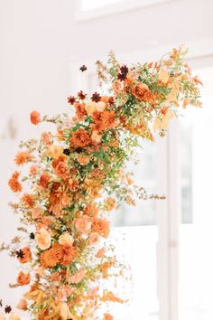 an arrangement of flowers is displayed on a table