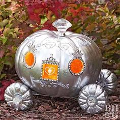 a metal pumpkin shaped like a carriage with orange eyes and an ornate design on the front