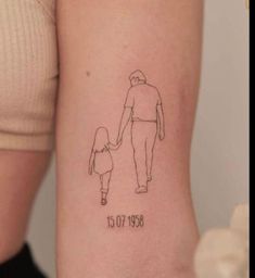 a woman's arm with a drawing of a man holding the hand of a child