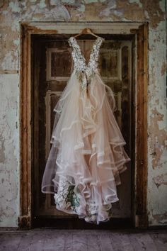 a dress hanging on a door in an old building