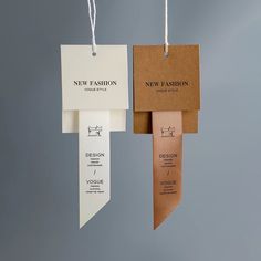 two new fashion tags hanging from strings on a gray background with white and brown paper