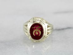 A classic 1930's retro era setting, lightly etched with linear and geometric designs - outfitted with a synthetic ruby stone, reverse-carved with the Shriner's symbol, this men's ring is one handsome piece! The Ancient Arabic Order of the Nobles of the Mystic Shrine, also commonly known as Shriners, is a men's fraternity organization associated with the Free Masons. The Shriner's symbol is inlaid into the ruby red stone with stunning saturated yellow gold! Metal: 14K Yellow Gold Gem: Red Glass G Free Masons, Yellow Gold Sapphire Ring, Retro Era, The Mystic, Cameo Ring, Ruby Stone, July Birthstone, Men's Ring, Red Stone