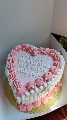 a heart shaped cake with pink and white frosting