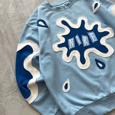 a blue sweatshirt with white and blue designs on the sleeves that say,'make '