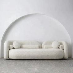 a white couch sitting on top of a cement floor