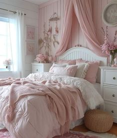 a bedroom with pink walls and white furniture