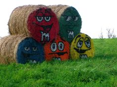 three hay bales with faces painted on them