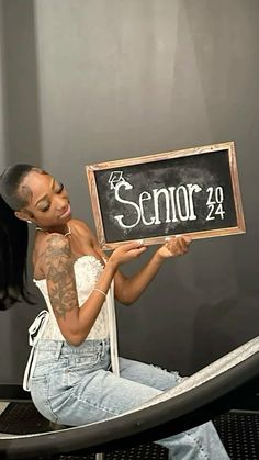 a woman sitting in a hammock holding up a sign that says senior 29