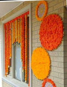 some orange and yellow decorations on the side of a brick wall in front of a window