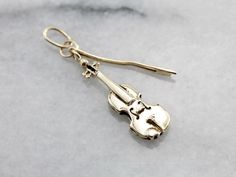 This vintage charm depicts a three dimensional instrument, a violin with it's bow. Slightly stylized, it's in excellent condition and quite pretty. A lovely good luck charm for your favorite musician! This pendant does not come with the chain shown. Please feel free to contact us, we will help you find the perfect chain for your style and budget! Metal: 14K Yellow Gold Measurements: 8 x 36 mm, with bail Marks: "A.C.14K" Stamped on the reverse Luck Charm, Love Charms, Luck Charms, Filigree Ring, Cute Charms, Anniversary Bands, Hand Engraving, Perfect Ring, Charm Necklaces