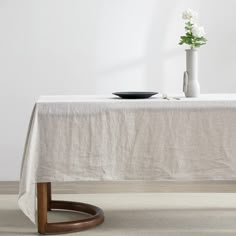 a table with a white cloth on it and a black plate sitting on top of it