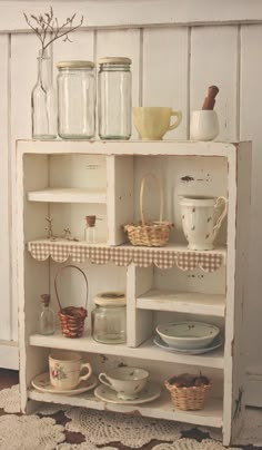 an old shelf with jars and dishes on it