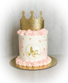 a cake with pink and gold frosting on top is decorated like a princess's crown