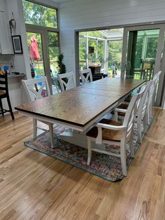 a large wooden table sitting in the middle of a living room next to a sliding glass door