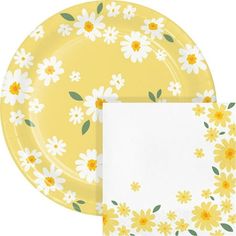 two plates with yellow and white flowers on them, one has a blank paper napkin