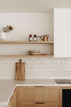 a kitchen with wooden cabinets and white tile backsplash, shelves above the sink