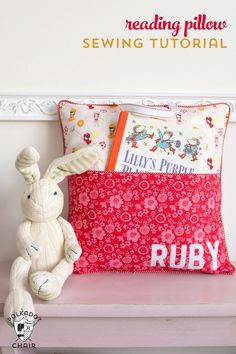 a stuffed bunny sitting on top of a bench next to a pillow with the words ruby printed on it