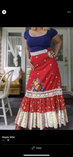 a woman wearing a red skirt and blue top