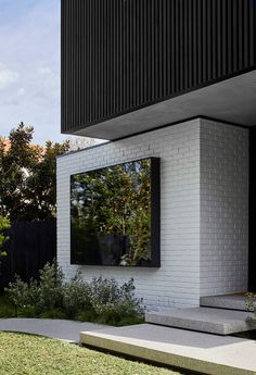 a white brick house with black shutters on the windows