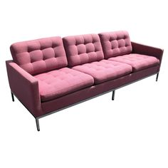 a pink couch sitting on top of a white floor