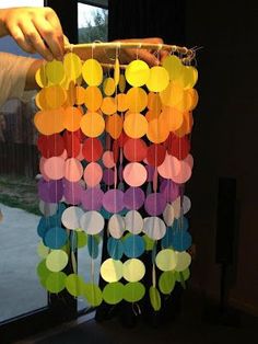 a person is making a mobile made out of paper circles