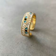 Introducing the Evil Eye Ring by Asana, a magical and stylish statement piece that is perfect for any outfit. This eye ring is made from high-quality metals with a beautiful gold finish. The center stone is an eye-shaped piece of enamel that is said to ward off evil spirits. This ring is adjustable to fit any finger size and makes a great gift for anyone who loves unique jewelry & needs some spiritual protection.      	Size: Adjustable - 6,7,8,9  	Free Shipping 2 Days  	Authentic Enamel Handmade Gold Enamel Ring, Handmade Gold Enamel Open Ring, Handmade Gold Open Enamel Ring, Gold Handmade Enamel Open Ring, Gold Enamel Ring As Gift, Gold Enamel Ring Gift, Gold Evil Eye Rings As Gifts, Gold Evil Eye Ring Gift, Gold Evil Eye Ring As A Gift