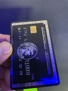 a hand holding up a blue credit card