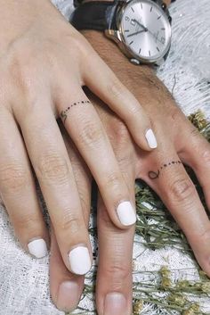 two people with matching rings on their fingers, one holding the other's hand