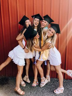 a group of young women standing next to each other wearing graduation caps and gowns