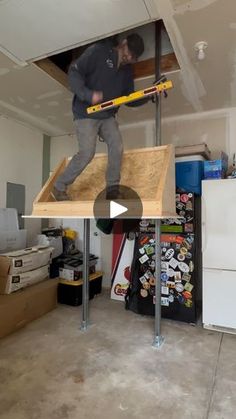 a man standing on top of a piece of plywood in a room under construction