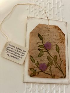 a piece of paper with flowers on it and a tag attached to the side of it