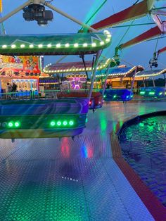 an amusement park at night with lights on the rides