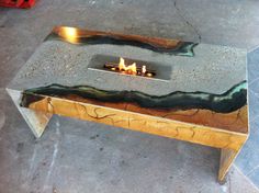 a fire pit made out of wood and metal with flames burning in the center on top