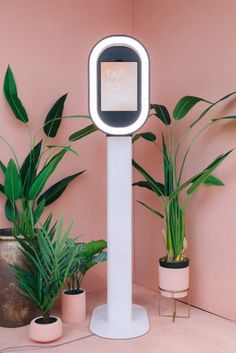 an electronic device is standing next to some potted plants