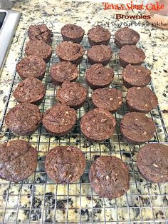 chocolate cupcakes cooling on a wire rack in the middle of a kitchen counter