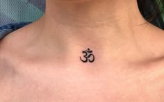 a woman with a tattoo on her neck has an omen symbol tattooed on her chest