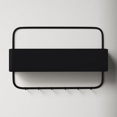 a black metal shelf mounted to the side of a wall next to a white wall