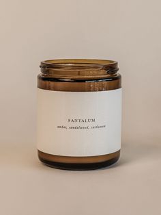 a candle with a label on it sitting in front of a white wall and floor