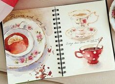 an open notebook on top of a table next to a bowl of cookies and a cup of tea