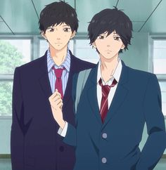 two young men in suits and ties standing next to each other with their hands on their hips