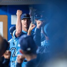 a baseball player is holding his fist up in the air while other players look on