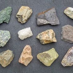 several different types of rocks sitting on top of a black surface next to each other