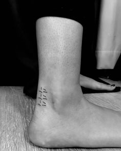 a black and white photo of a person's foot with the word faith on it