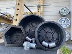 two large black wheels sitting next to each other on top of a cement slab in front of a building