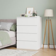 a bedroom with green walls and white furniture