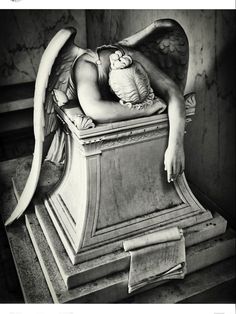 an angel statue sitting on top of a wooden table