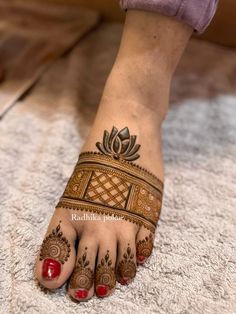 a woman's foot with henna tattoos on it