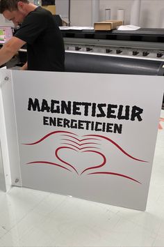 a man standing behind a sign that says magnetiseur energeticien